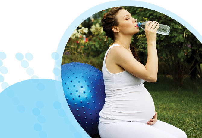 אישה בהריון שותה מים אחרי אימון
