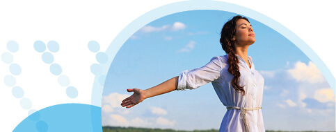 אישה לבושה לבן פושטת ידיים אחורה על רקע שדה ושמים כחולים