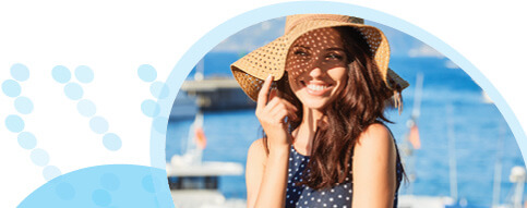 אישה עם שיער חום ארוך מחייכת וחובשת כובע קשה המצל על פניה