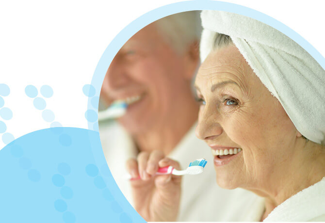 גבר ואישה מבוגרים עם שיער לבן מצחצחים שיניים