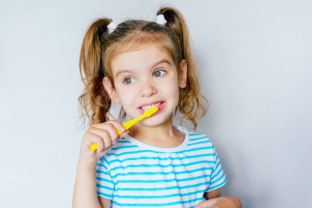 ילדה מצחצחת שיניים